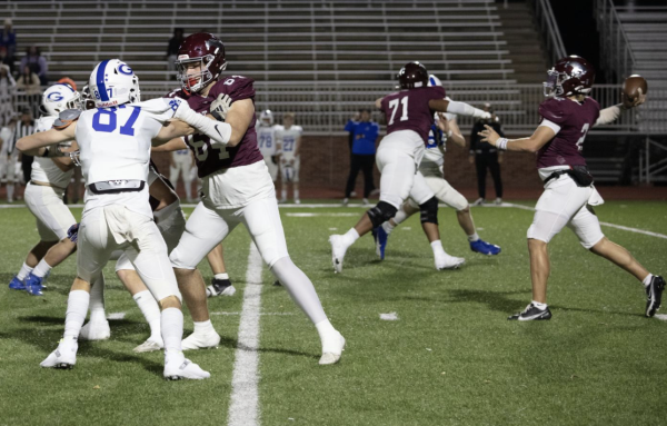 Central quarterback Jack Gordon (right) gets blocks from junior Kaden Snyder (left) and sophomore Warwick VanBlaricon as he winds up to throw a pass vs. Goddard. The Mustangs' 52-24 victory over the state-ranked Lions was a highlight of the season. 